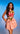 Woman wearing a pink dress with floral designs against a blue background